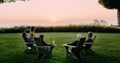 Family with wine glasses in chairs at sunset